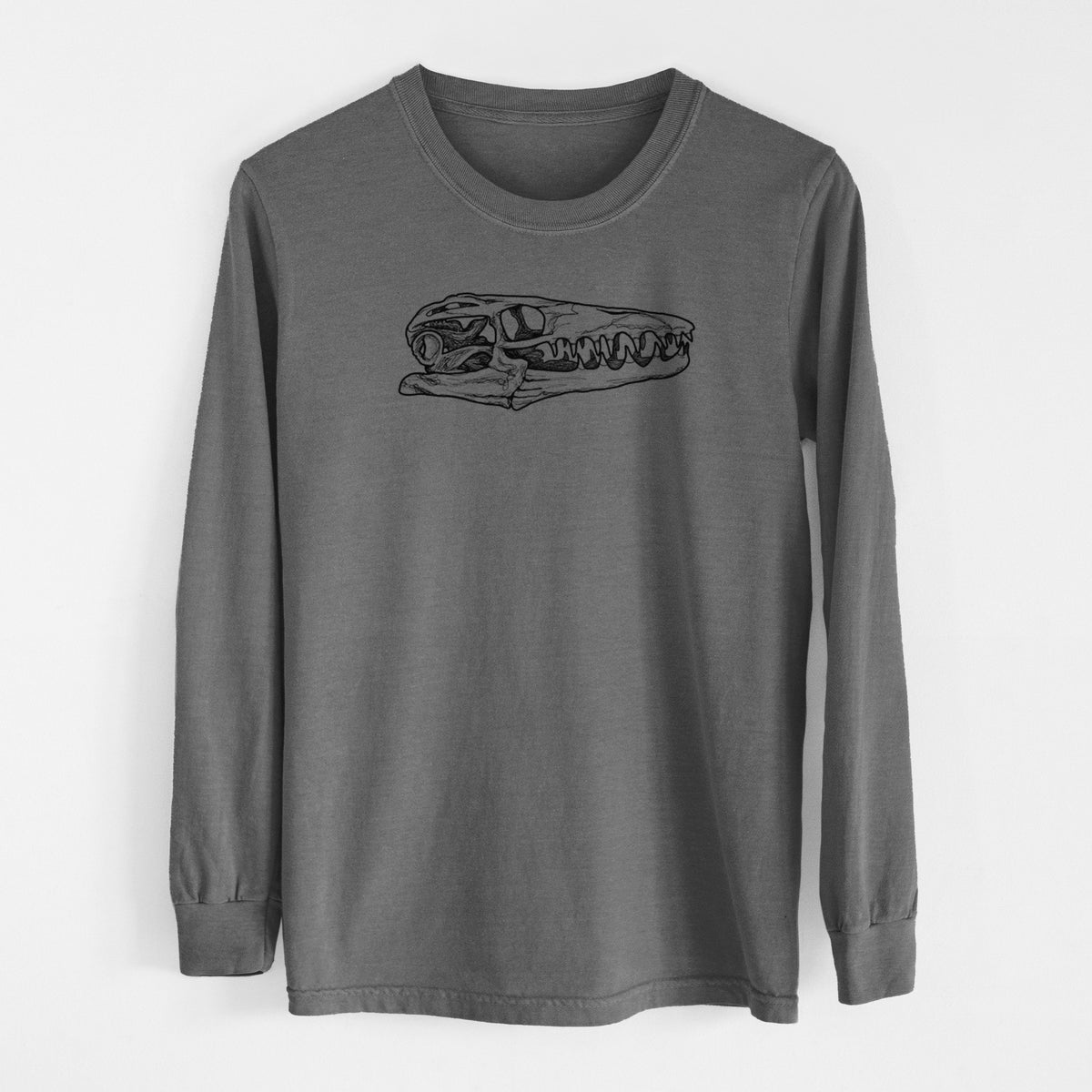Pepper Comfort Colors long sleeve shirt laid flat, printed with a detailed black ink illustration of a Mosasaur skull.