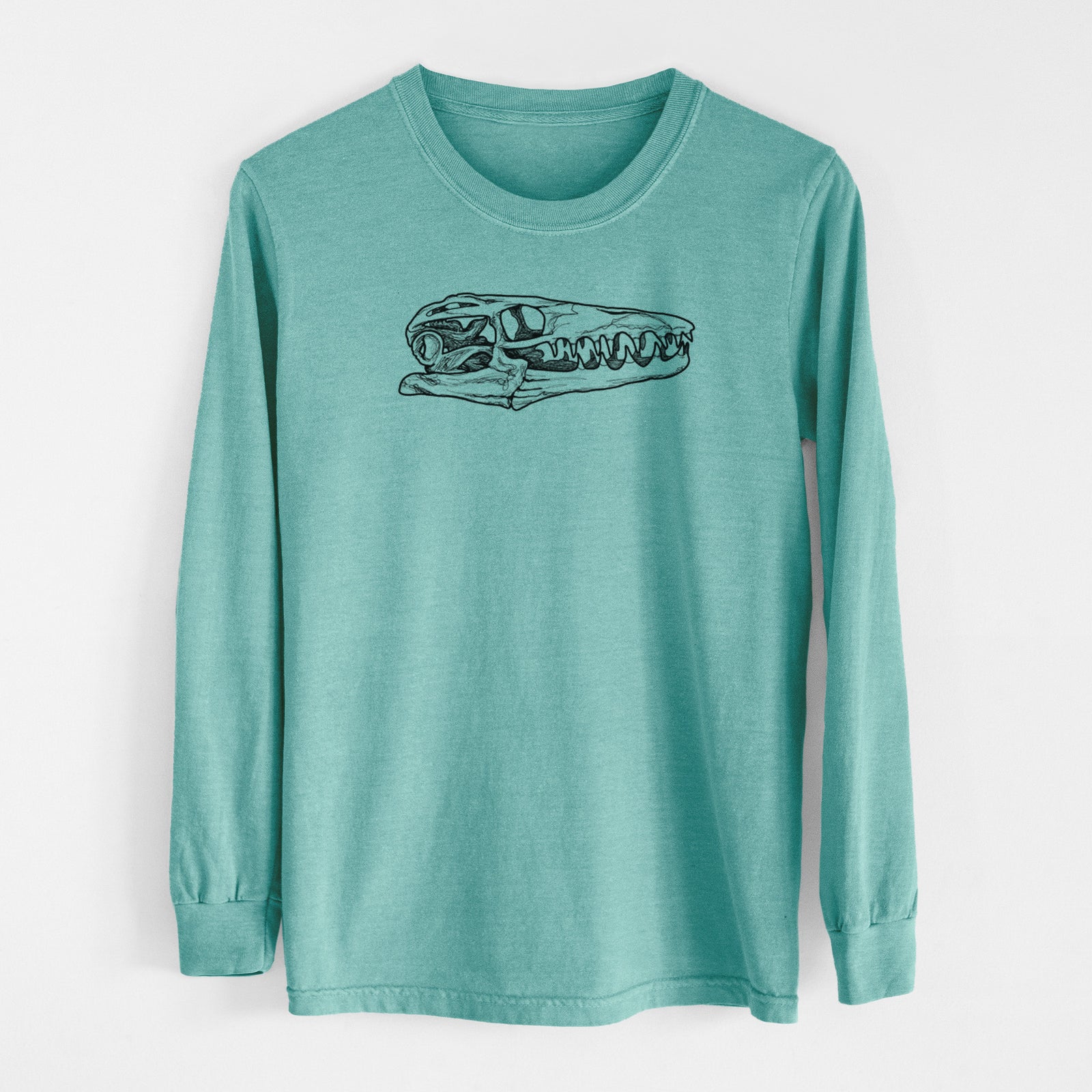 Reef green Comfort Colors long sleeve shirt laid flat, printed with a detailed black ink illustration of a Mosasaur skull.