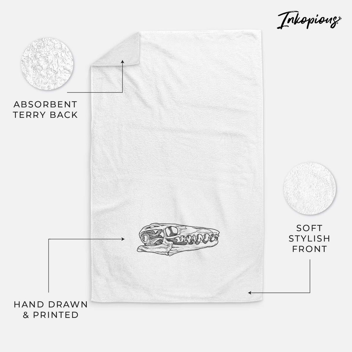 White hand towel printed with a detailed black ink illustration of a Mosasaur skull.
