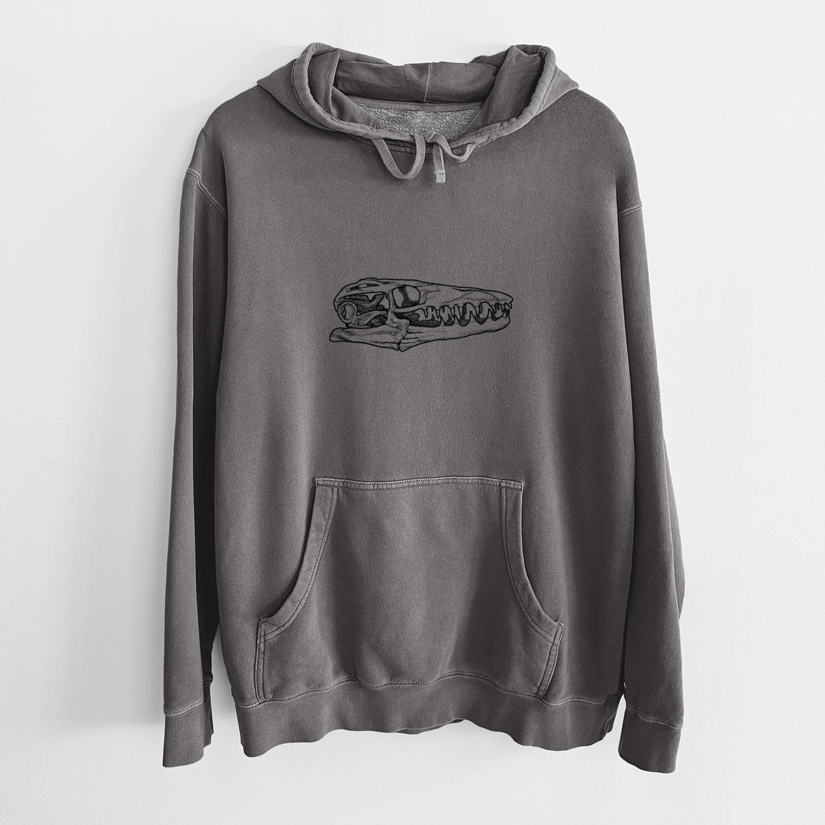 Faded black pigment dyed hoodie laid flat, printed with a detailed black ink illustration of a Mosasaur skull.