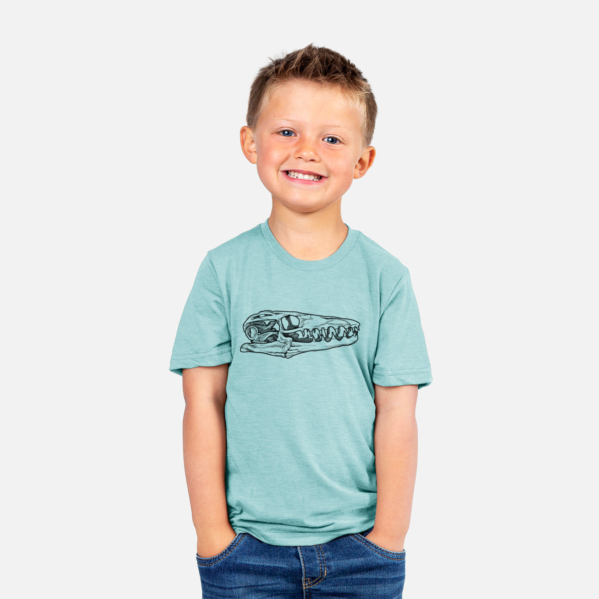 Smiling boy wearing a youth t-shirt printed with a detailed black ink illustration of a Mosasaur skull.