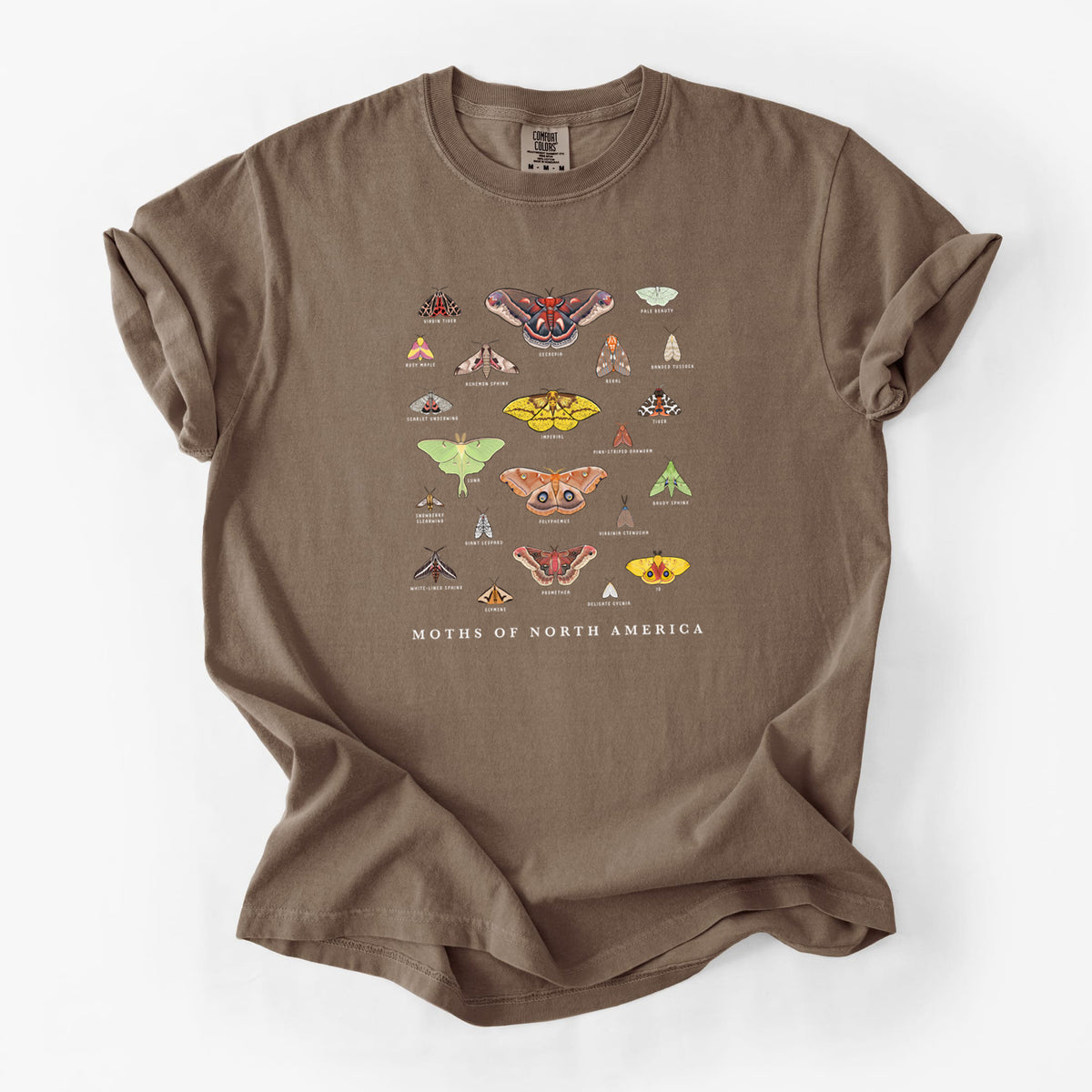 Espresso brown Comfort Colors t-shirt laid flat, printed with a full-color chart of North American moths, each labeled with its species.