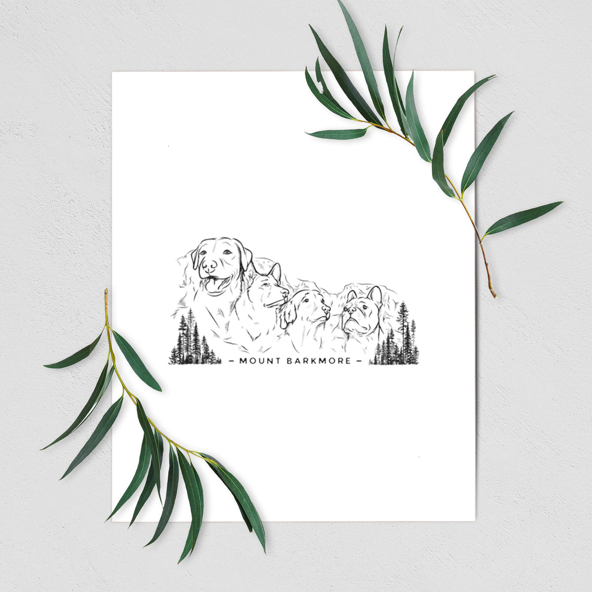Art print of a black ink illustration of four dog faces carved into a mountain, with the words Mount Barkmore, shown with eucalyptus leaves.