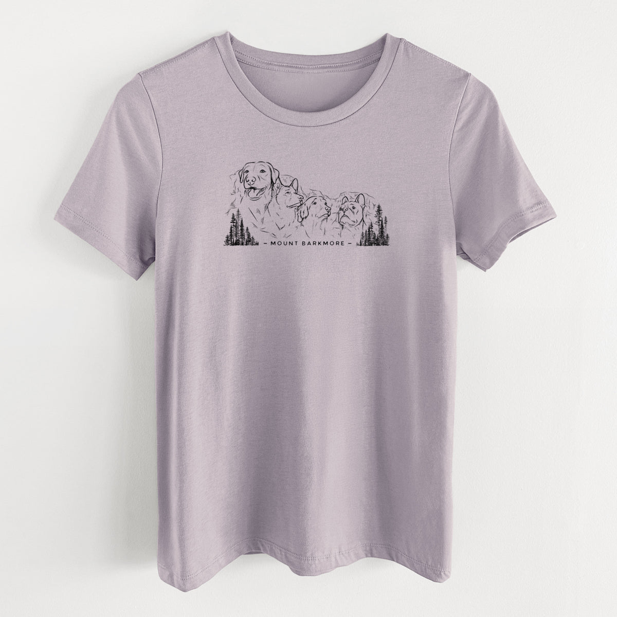 Light violet women's relaxed fit cotton t-shirt laid flat, printed with a black ink illustration of four dog faces carved into a mountain, with the words Mount Barkmore.