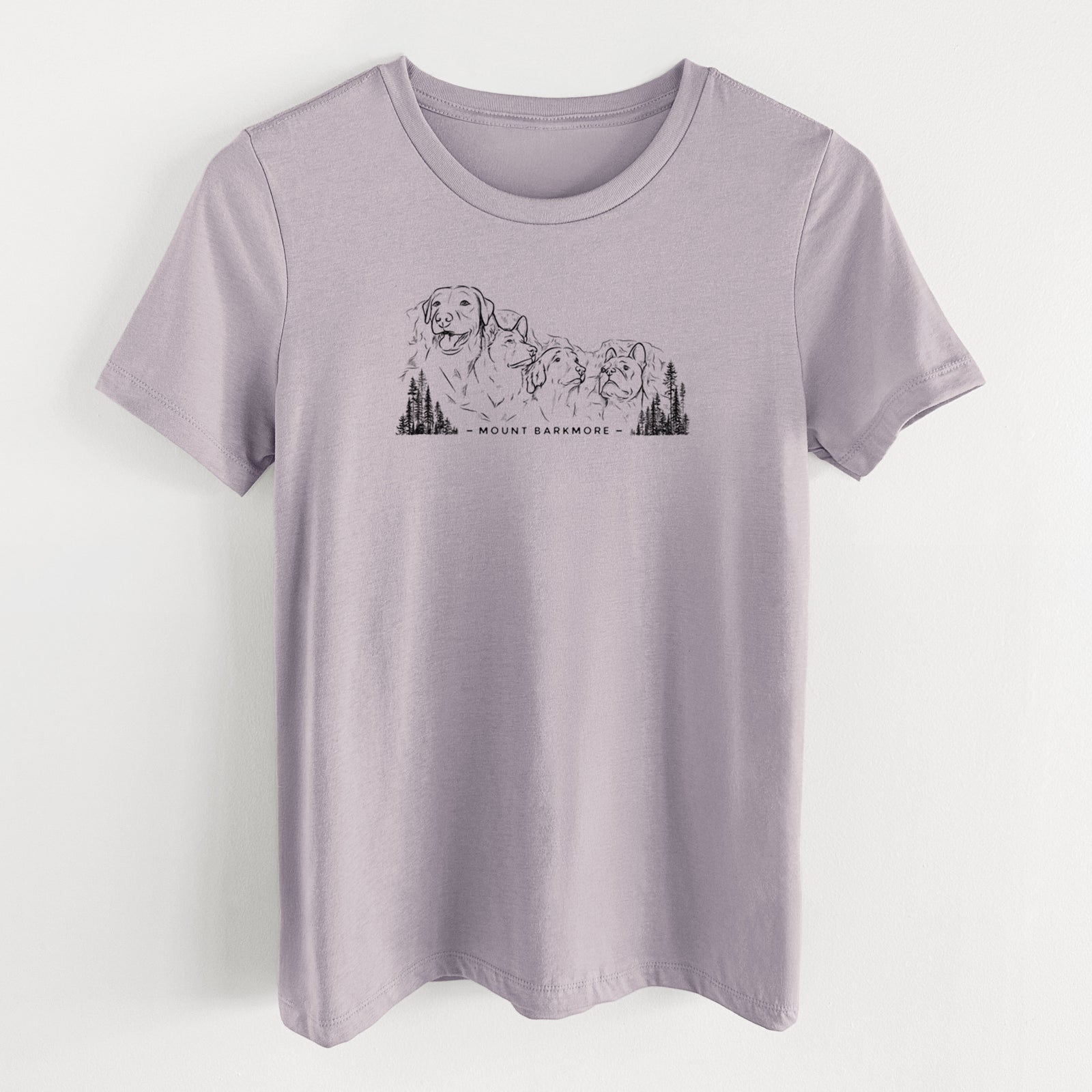 Light violet women's relaxed fit cotton t-shirt laid flat, printed with a black ink illustration of four dog faces carved into a mountain, with the words Mount Barkmore.