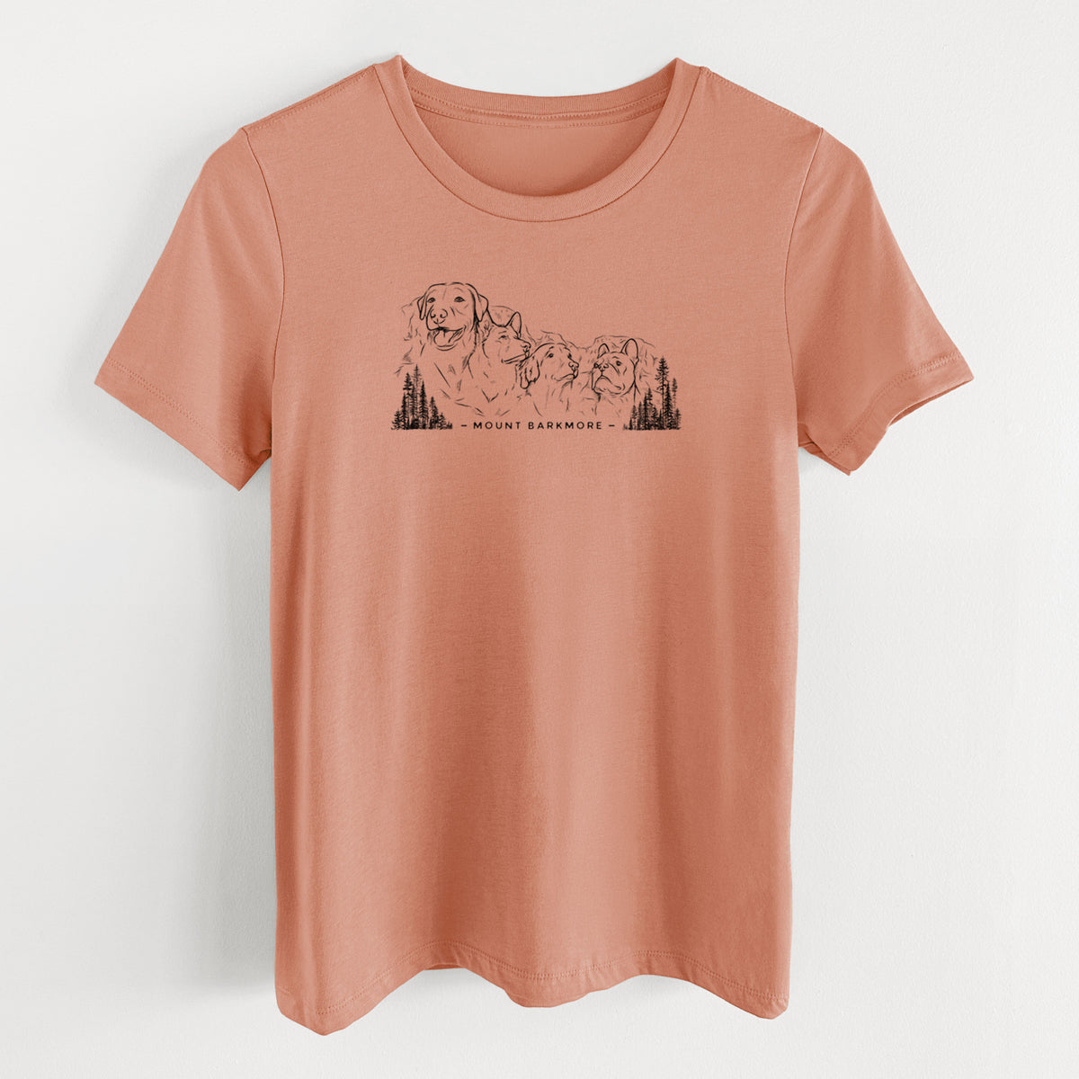 Terracotta orange women's relaxed fit cotton t-shirt laid flat, printed with a black ink illustration of four dog faces carved into a mountain, with the words Mount Barkmore.