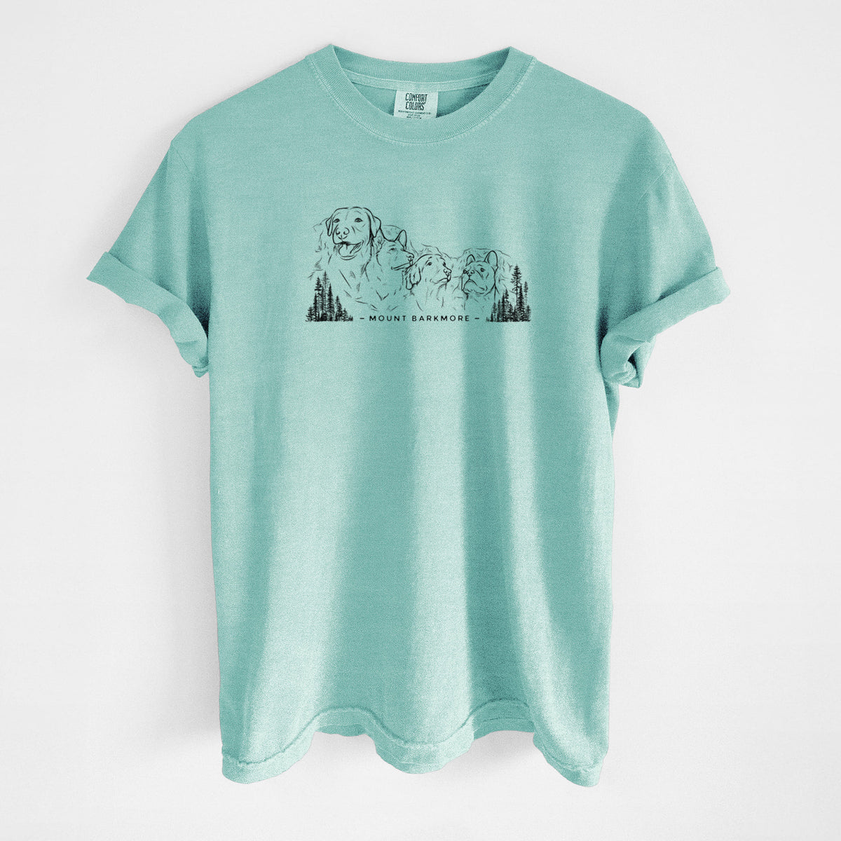 Chalky mint Comfort Colors t-shirt laid flat, printed with a black ink illustration of four dog faces carved into a mountain, with the words Mount Barkmore.