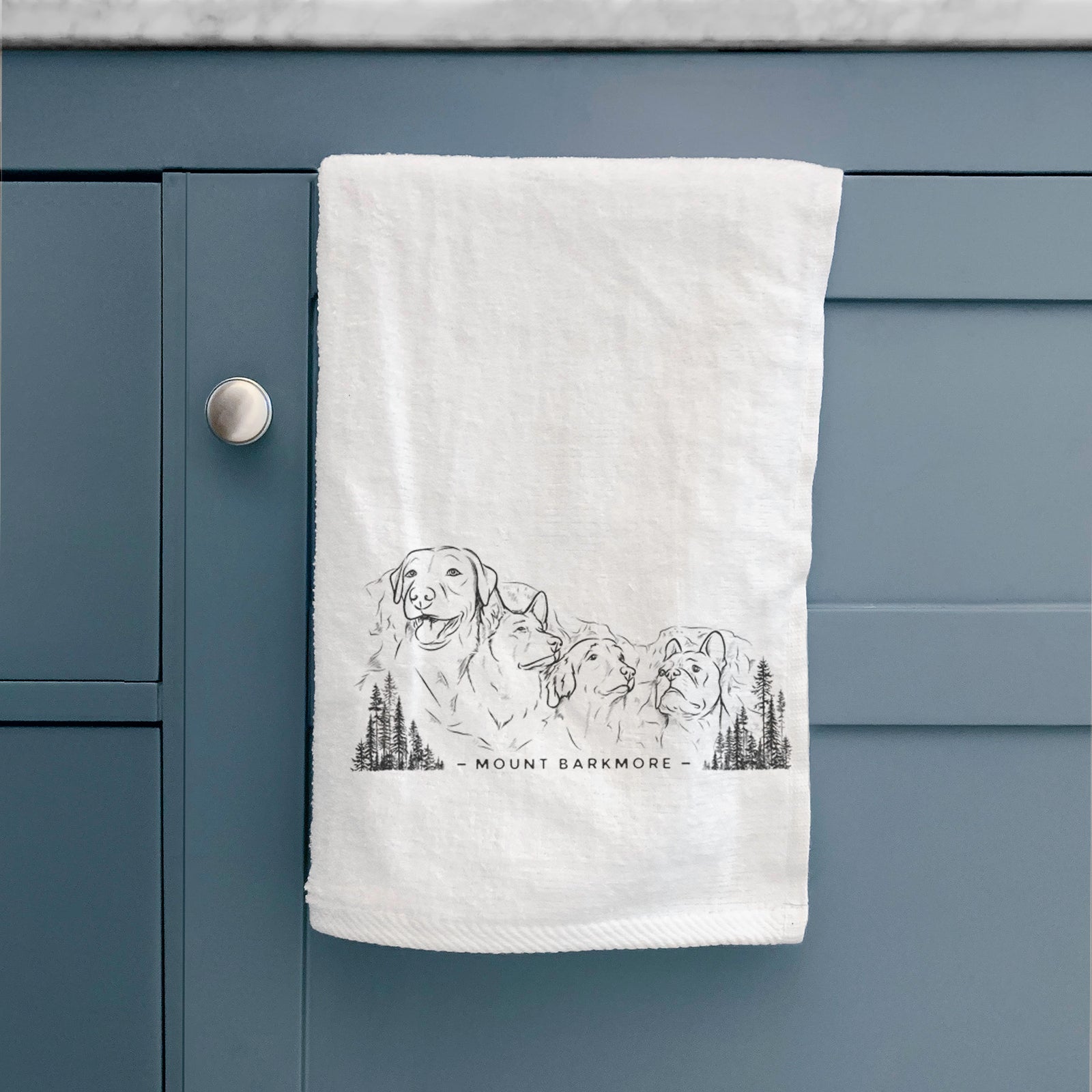 White hand towel printed with a black ink illustration of four dog faces carved into a mountain, with the words Mount Barkmore.