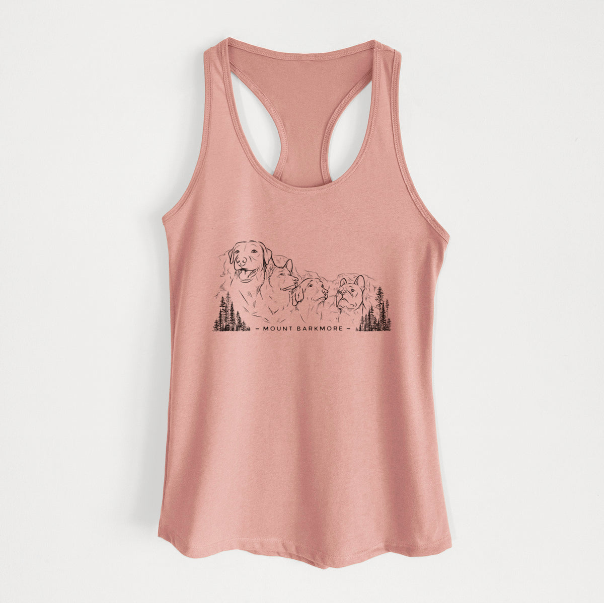 Desert pink women's racerback tank top laid flat, printed with a black ink illustration of four dog faces carved into a mountain, with the words Mount Barkmore.