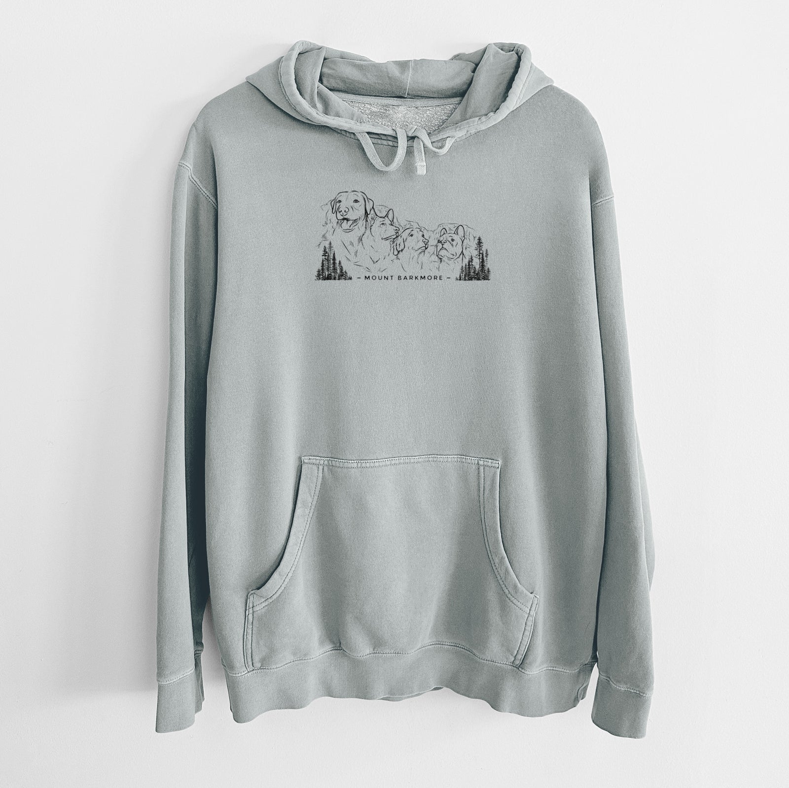 Sage green pigment dyed hoodie laid flat, printed with a black ink illustration of four dog faces carved into a mountain, with the words Mount Barkmore.