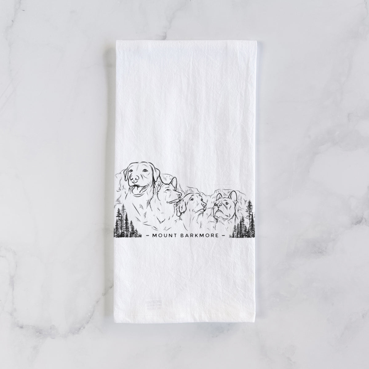White cotton tea towel laid flat on marble, printed with a black ink illustration of four dog faces carved into a mountain, with the words Mount Barkmore.