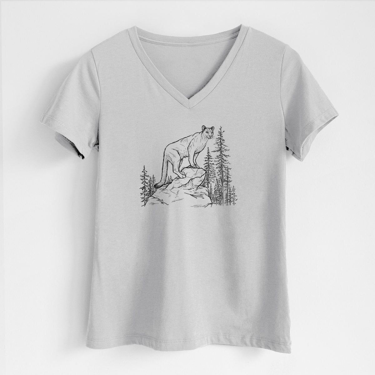 Lunar grey women's relaxed fit cotton V-neck t-shirt laid flat, printed with a black ink illustration of a mountain lion standing on a rocky ledge among pine trees.