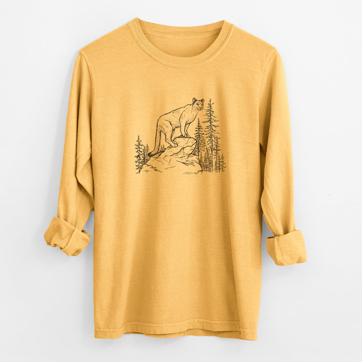 Golden wheat yellow Comfort Colors long sleeve shirt laid flat with the cuffs rolled, printed with a black ink illustration of a mountain lion standing on a rocky ledge among pine trees.