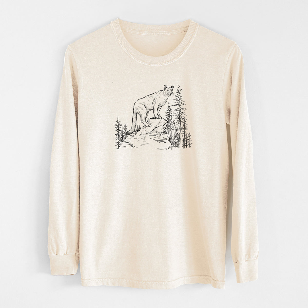 Ivory Comfort Colors long sleeve shirt laid flat, printed with a black ink illustration of a mountain lion standing on a rocky ledge among pine trees.