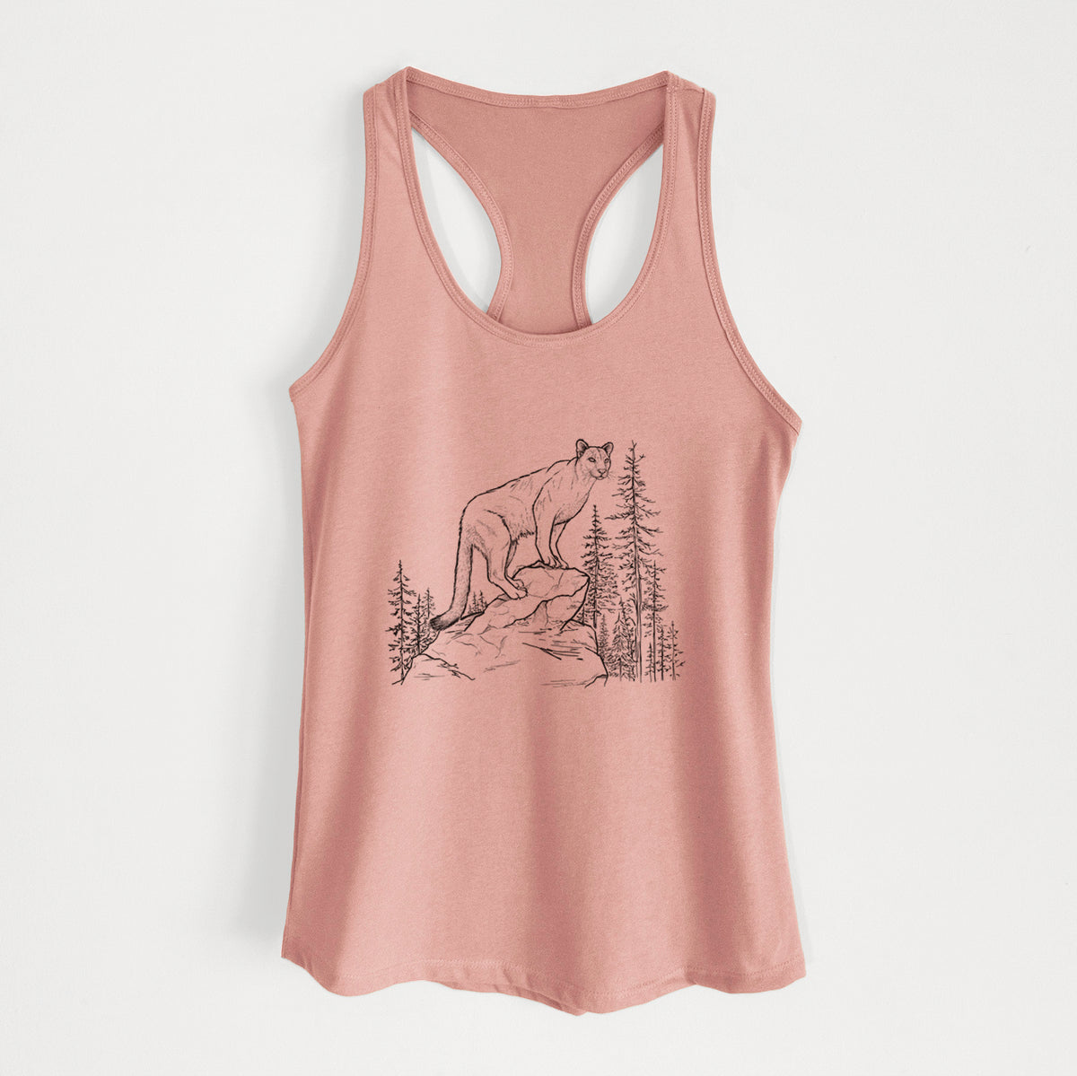 Desert pink women's racerback tank top laid flat, printed with a black ink illustration of a mountain lion standing on a rocky ledge among pine trees.