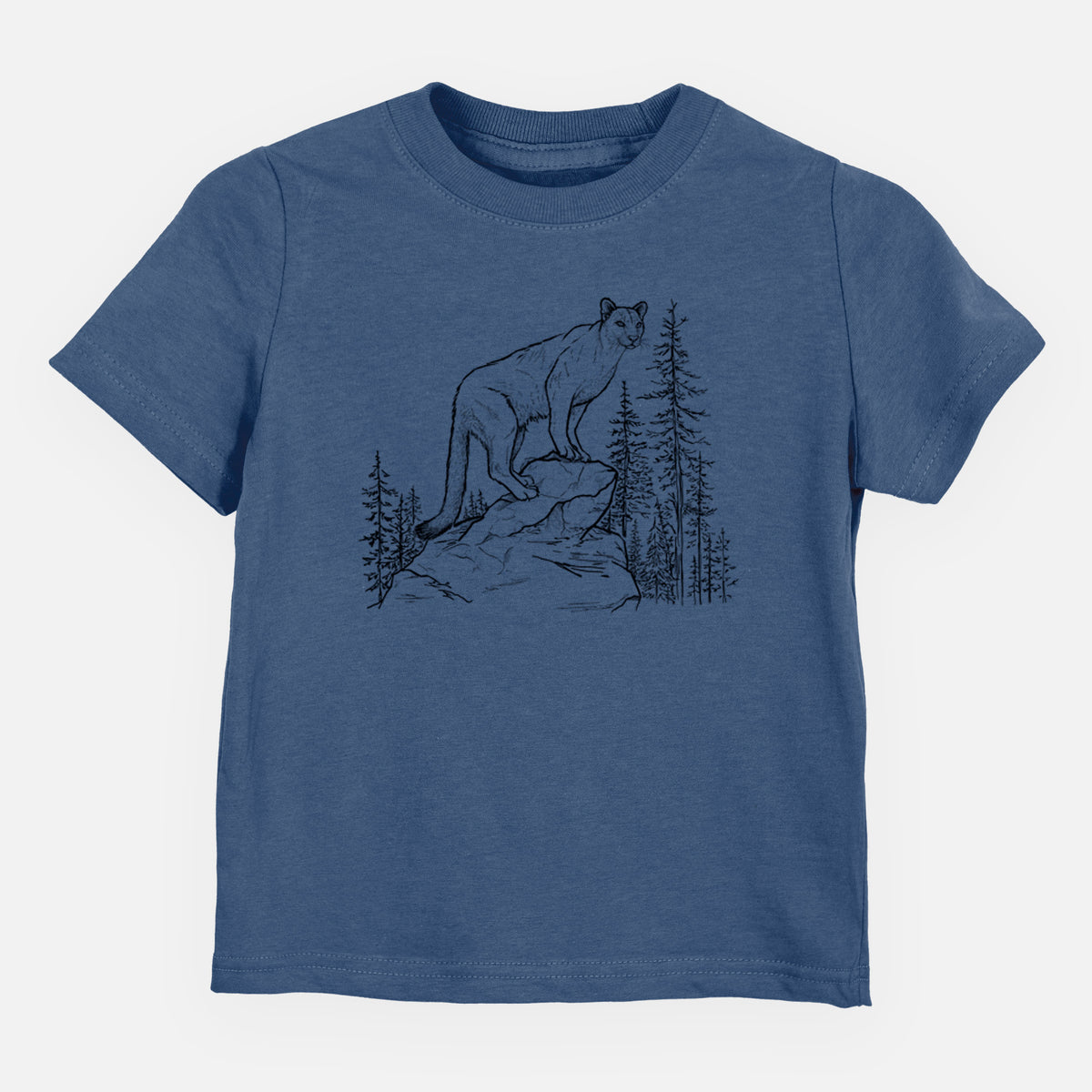 Indigo blue toddler t-shirt laid flat, printed with a black ink illustration of a mountain lion standing on a rocky ledge among pine trees.