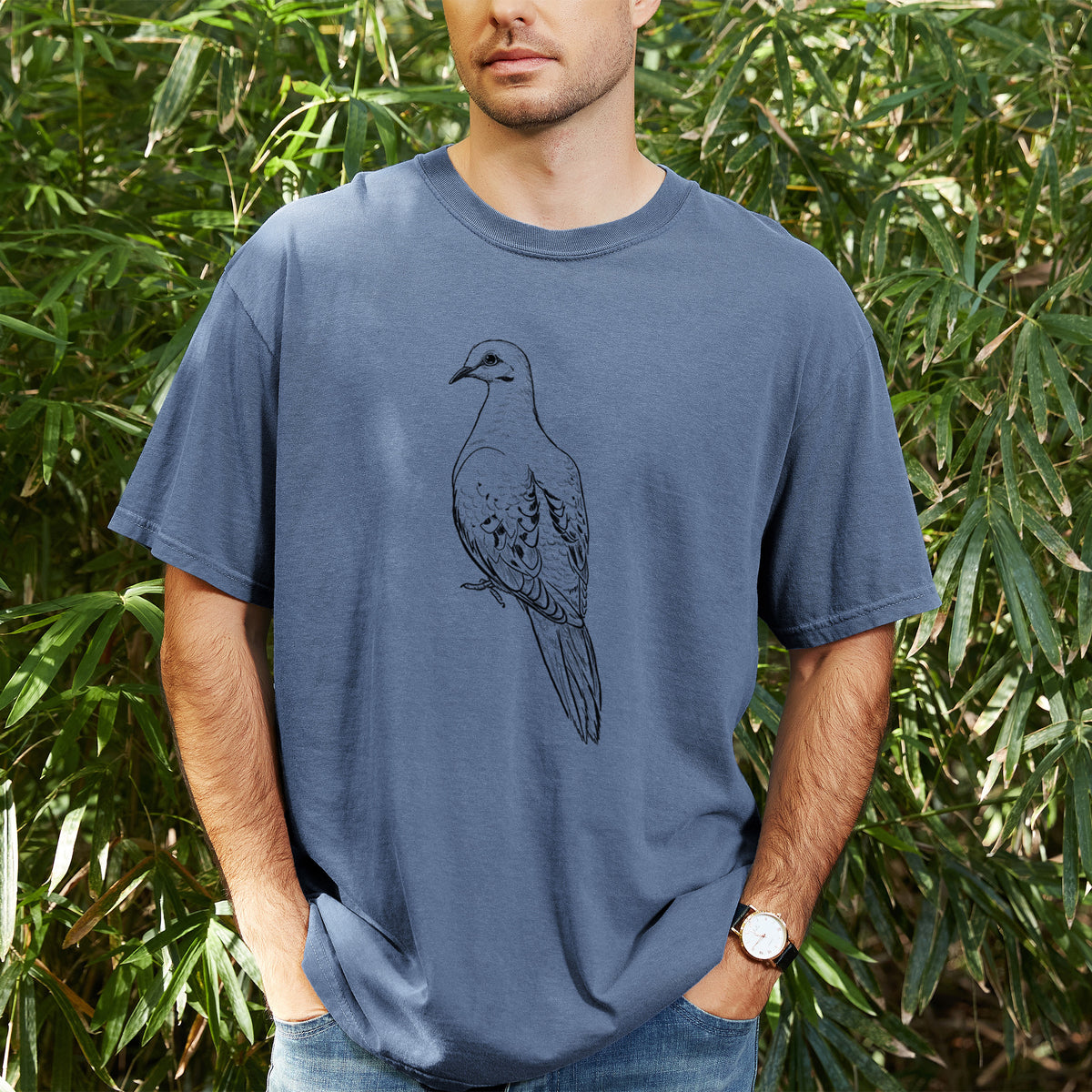Man wearing a Comfort Colors t-shirt printed with a detailed black ink sketch of a mourning dove perched, outdoors.