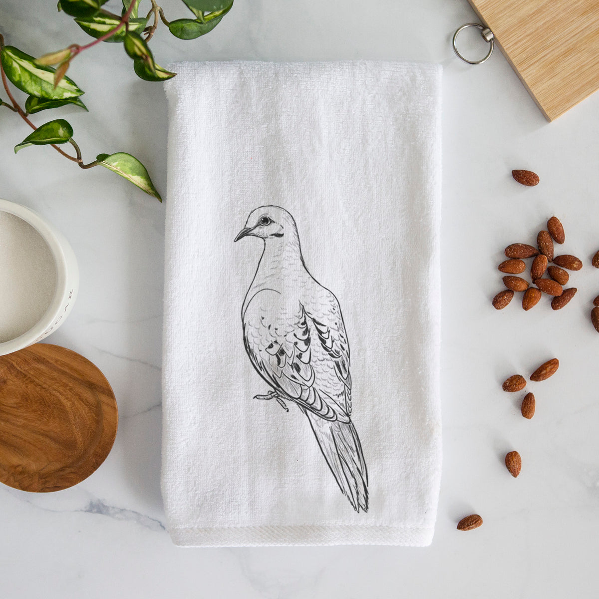 White hand towel printed with a detailed black ink sketch of a mourning dove perched.