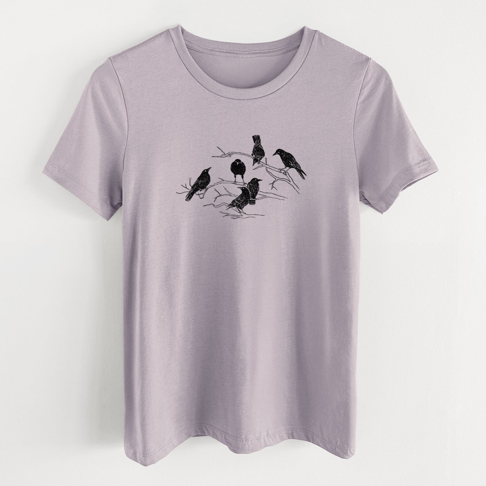 Light violet women's relaxed fit cotton t-shirt laid flat, printed with a black ink illustration of a group of crows perched on bare branches.
