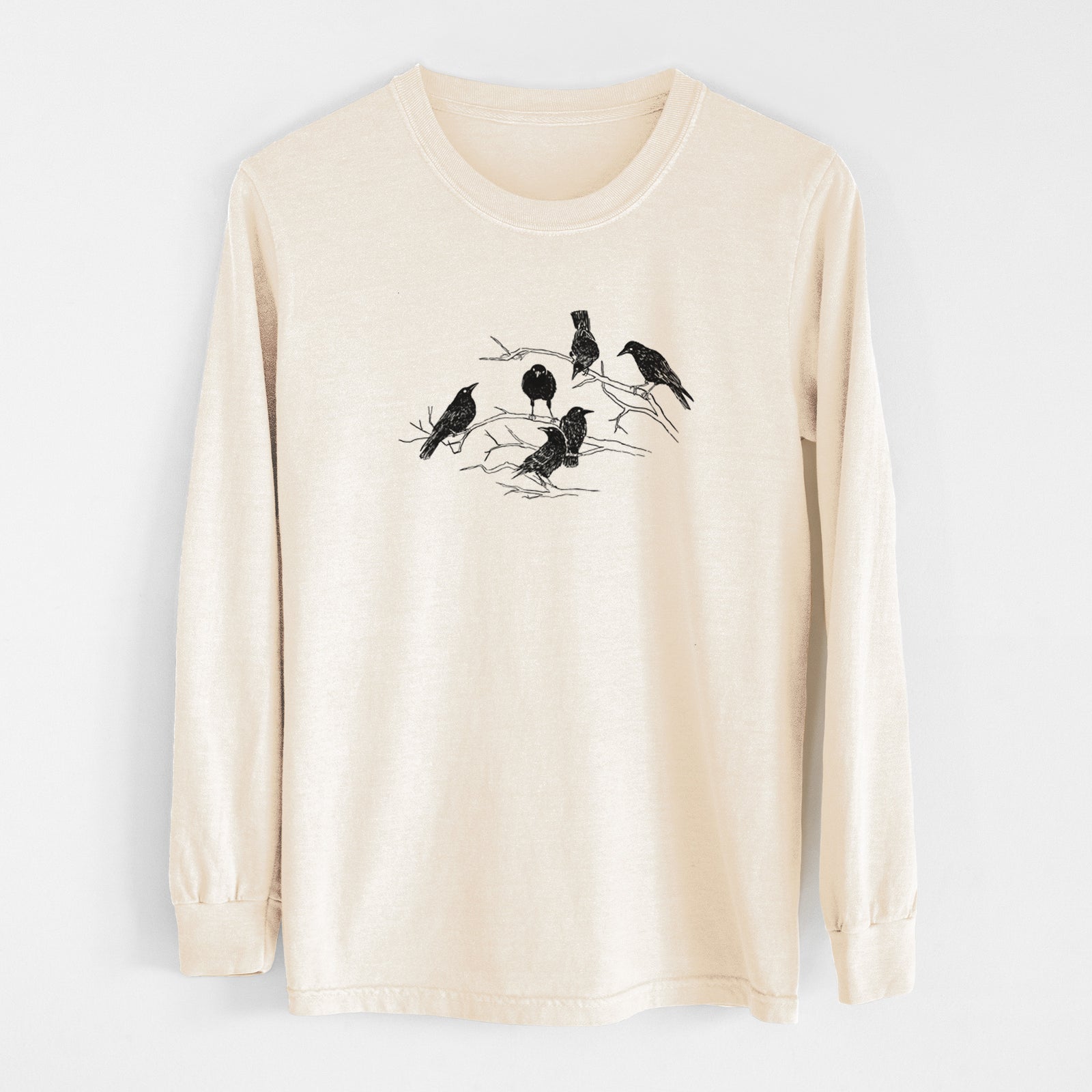 Ivory Comfort Colors long sleeve shirt laid flat, printed with a black ink illustration of a group of crows perched on bare branches.