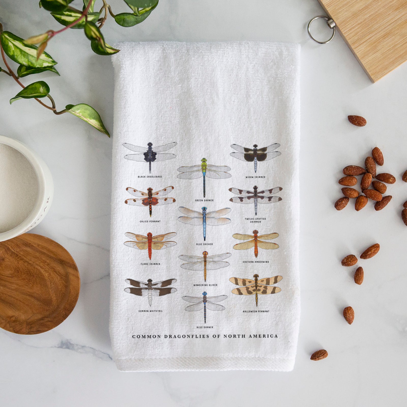 White hand towel printed with a full-color chart of North American dragonflies, each labeled with its species.