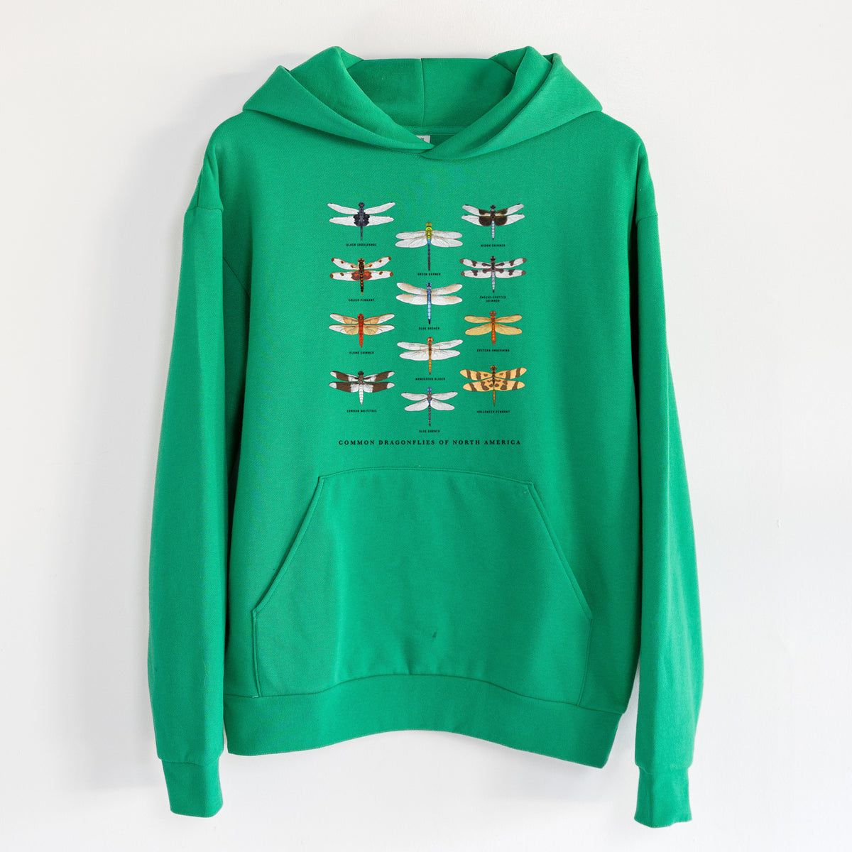 Common Dragonflies of North America - Statement Midweight Hoodie in Kelly Green, hanging on a white wall, with a front kangaroo pocket and no drawcords.