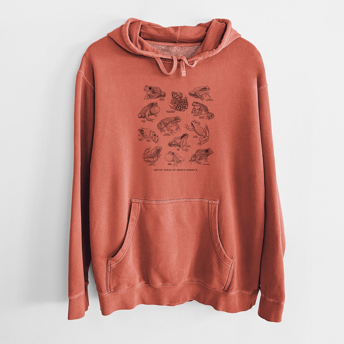Amber orange pigment dyed hoodie laid flat, printed with a chart of black ink illustrations of North American frog species.