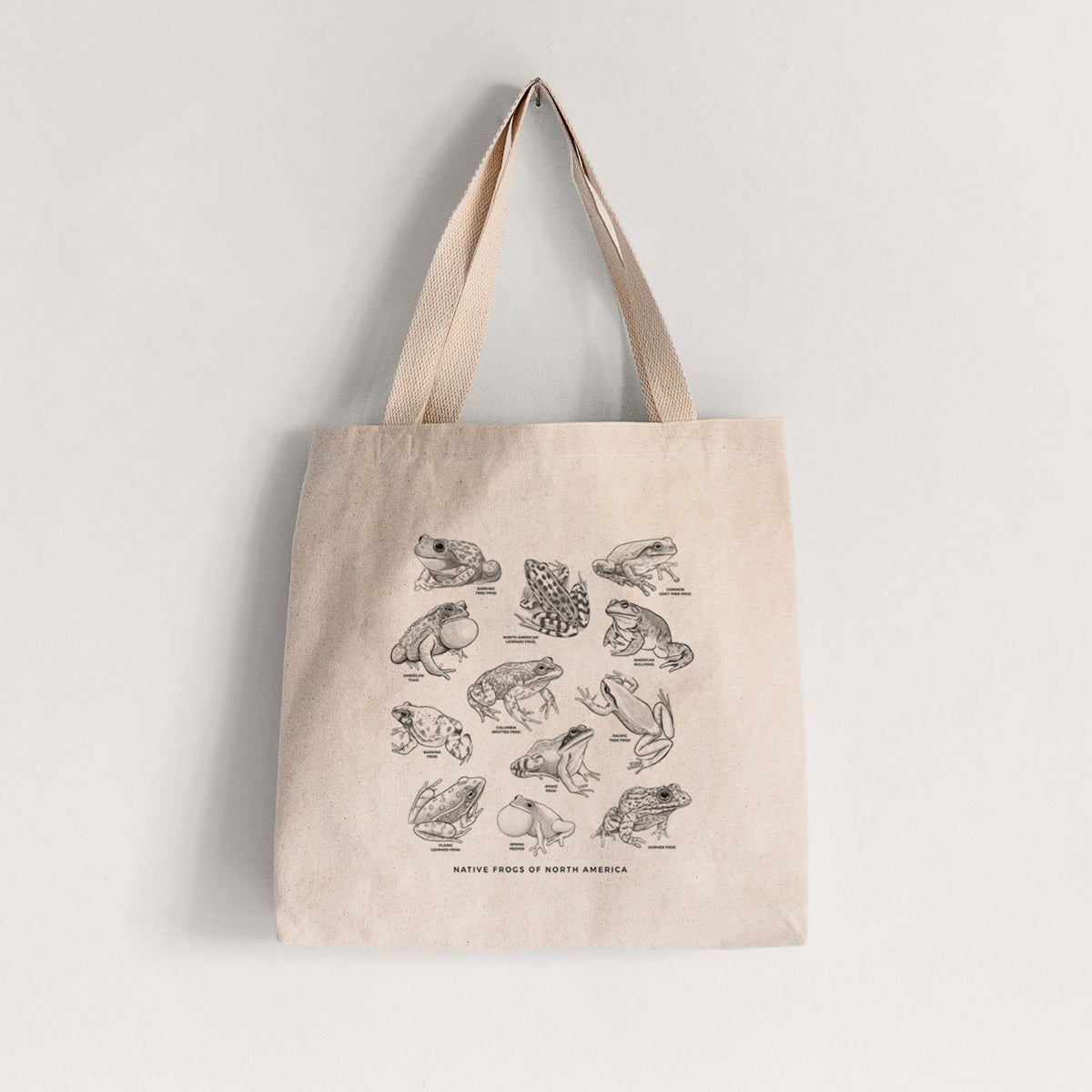 Natural canvas tote bag printed with a chart of black ink illustrations of North American frog species.
