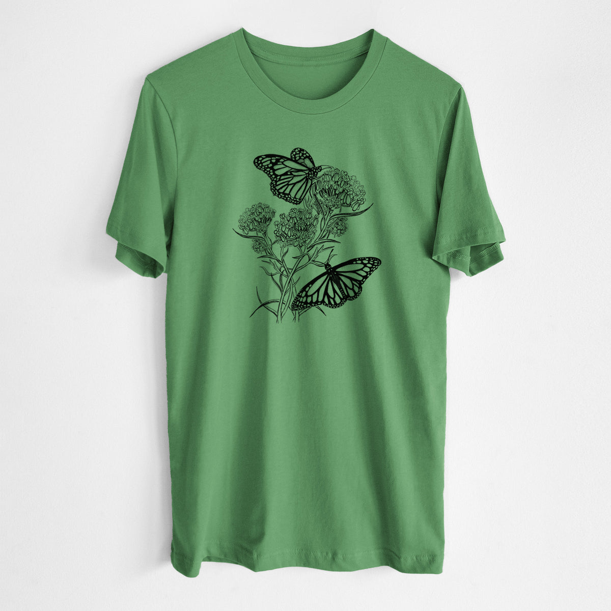 Leaf green lightweight cotton t-shirt laid flat, printed with a black ink illustration of two monarch butterflies on flowering milkweed.