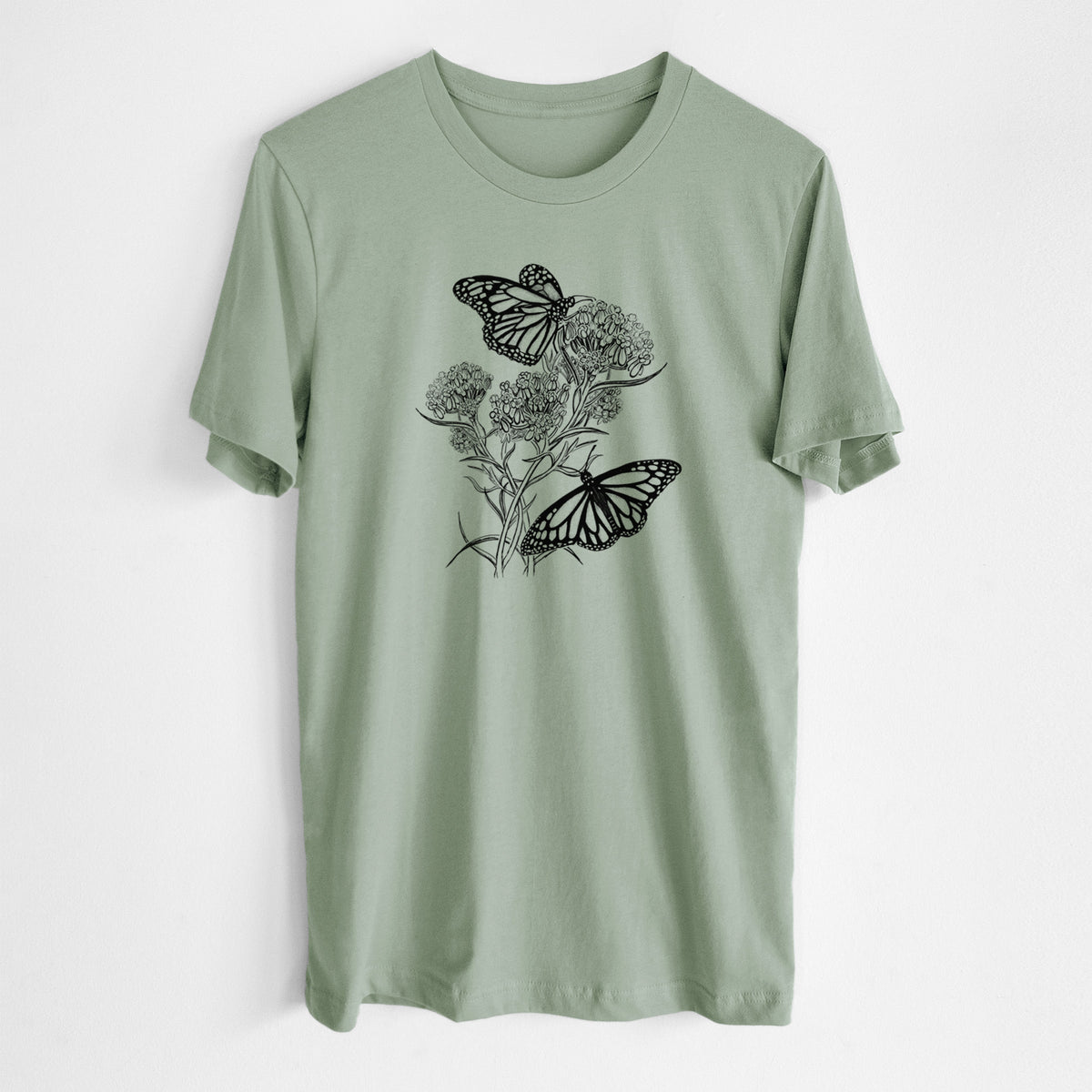 Sage green lightweight cotton t-shirt laid flat, printed with a black ink illustration of two monarch butterflies on flowering milkweed.