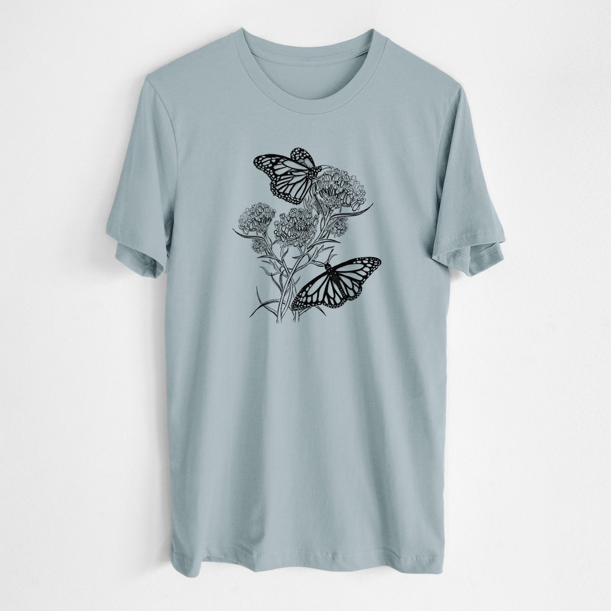 Vintage denim lightweight cotton t-shirt laid flat, printed with a black ink illustration of two monarch butterflies on flowering milkweed.