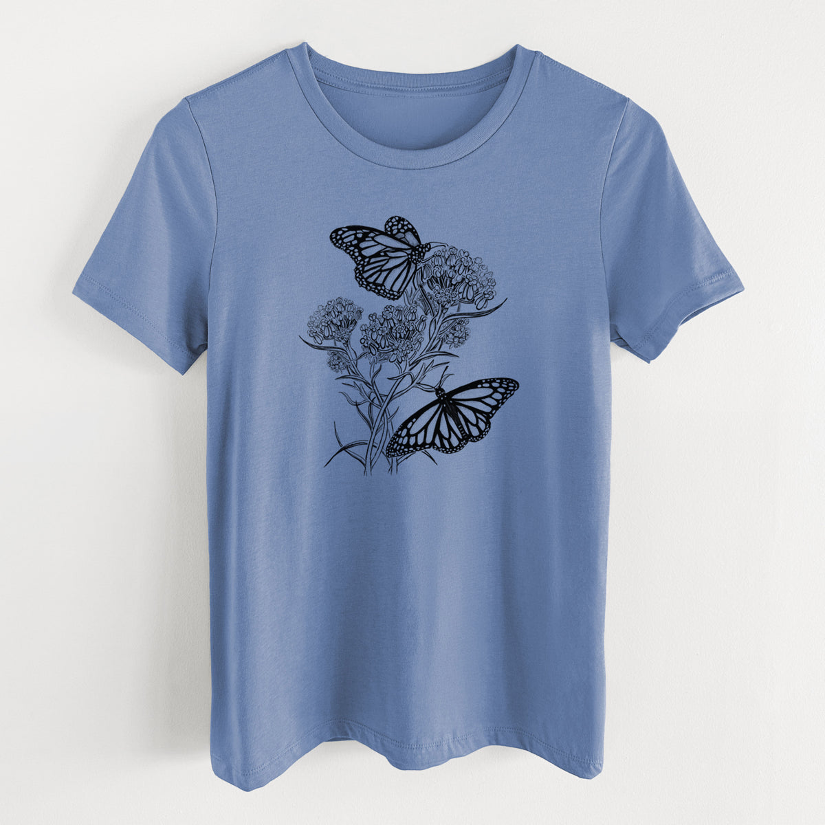 Blue bell women's relaxed fit cotton t-shirt laid flat, printed with a black ink illustration of two monarch butterflies on flowering milkweed.