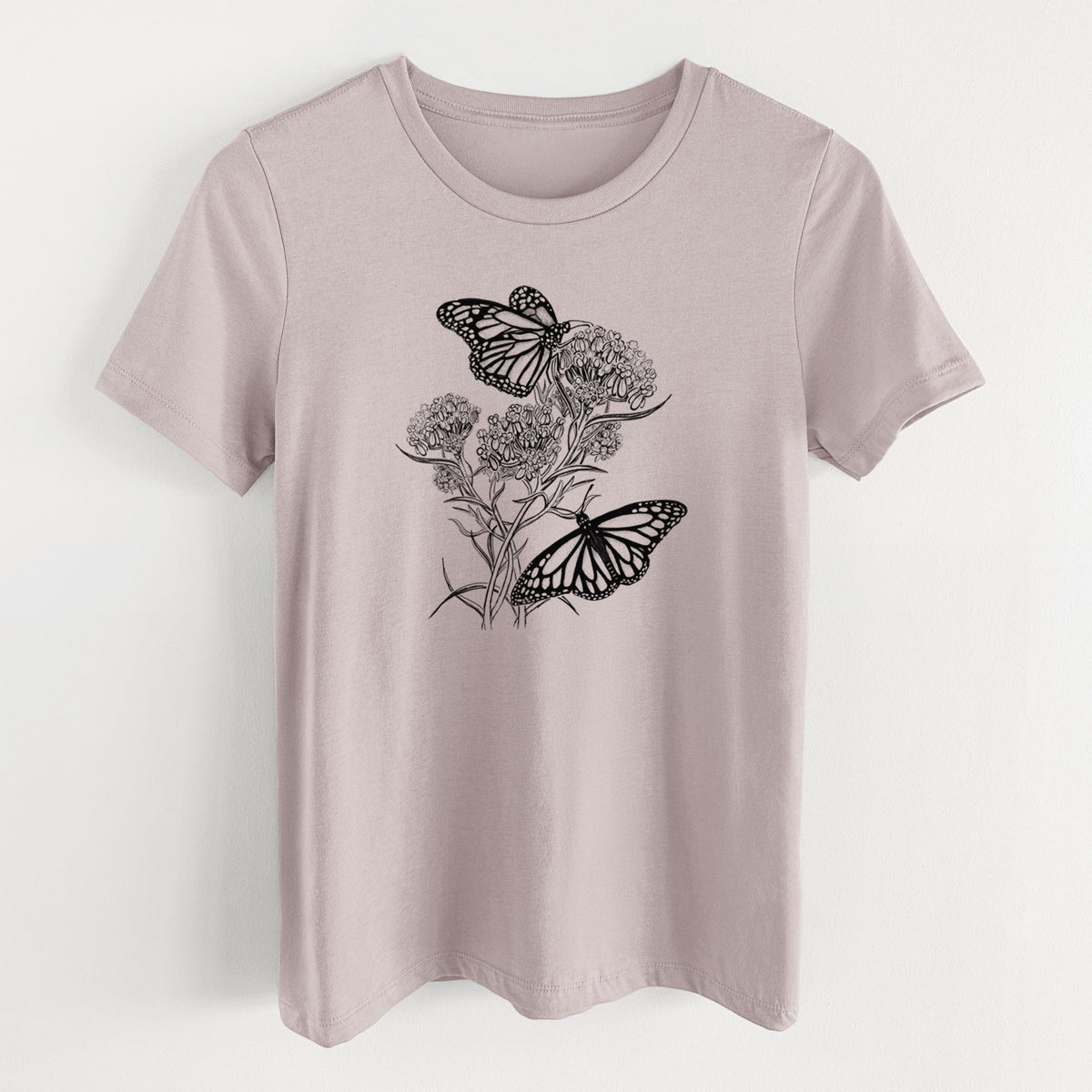 Pink gravel women's relaxed fit cotton t-shirt laid flat, printed with a black ink illustration of two monarch butterflies on flowering milkweed.