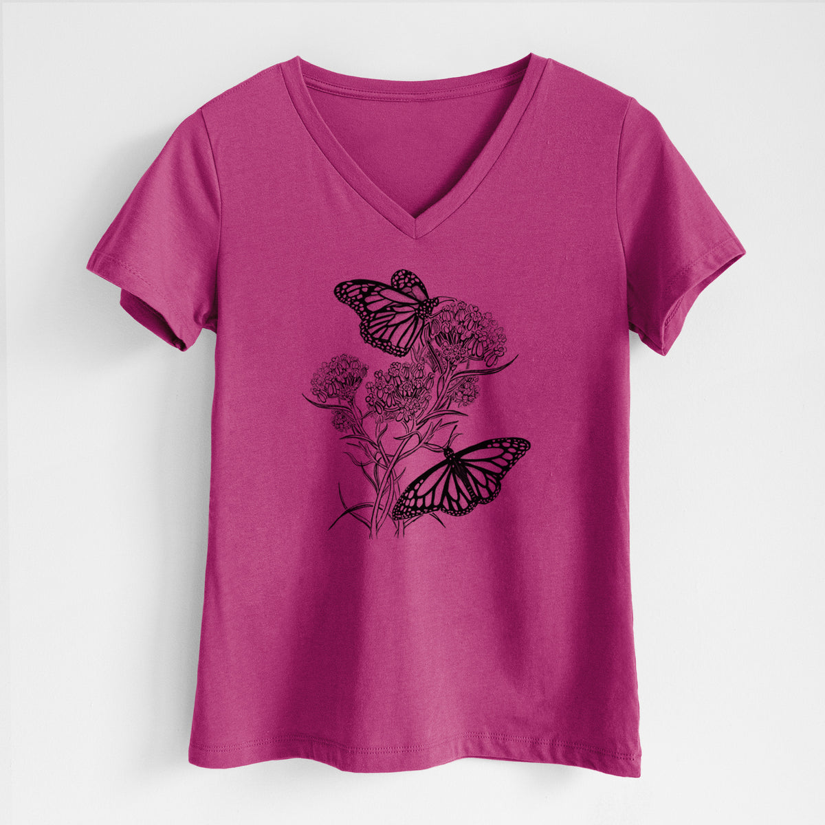 Berry pink women's relaxed fit cotton V-neck t-shirt laid flat, printed with a black ink illustration of two monarch butterflies on flowering milkweed.