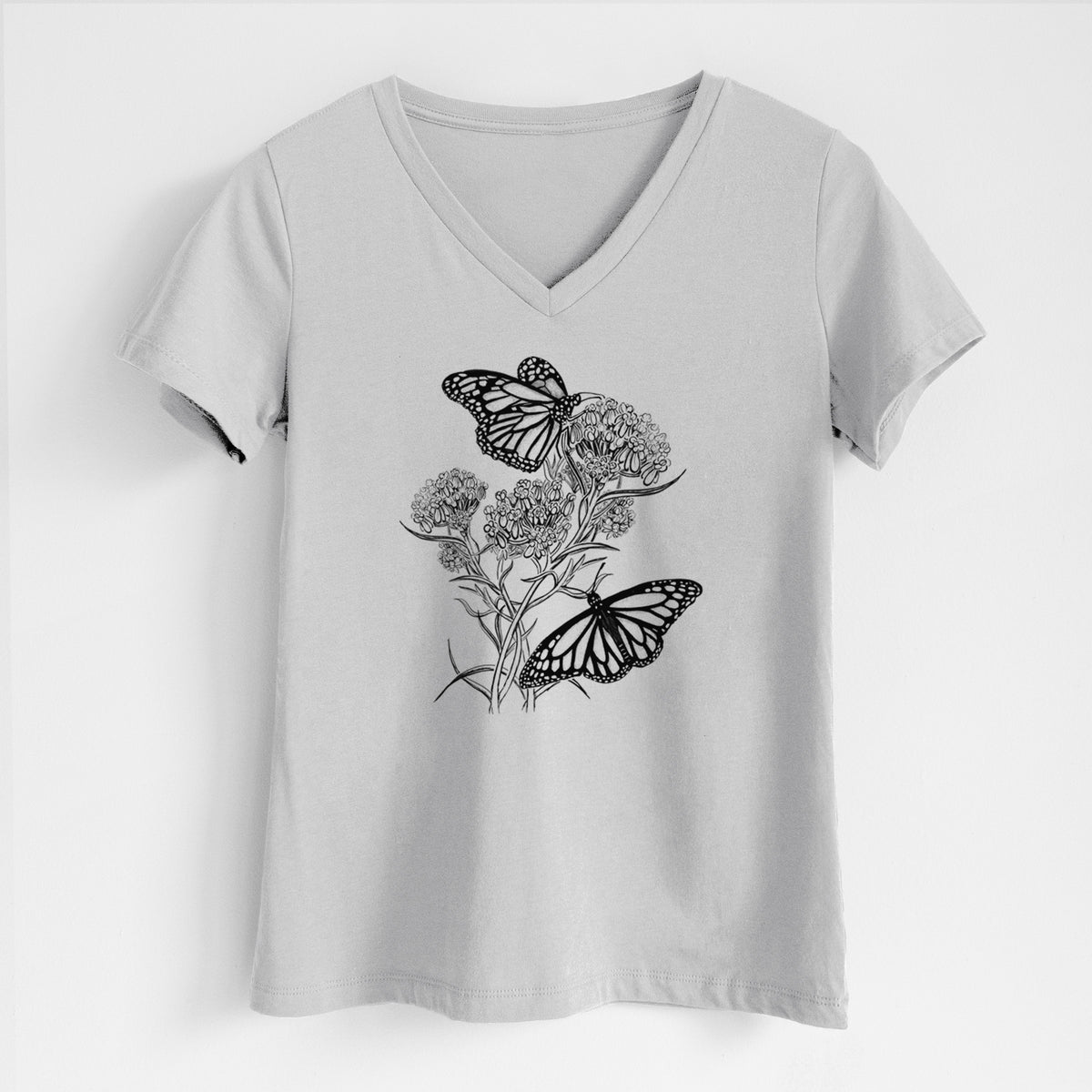 Lunar grey women's relaxed fit cotton V-neck t-shirt laid flat, printed with a black ink illustration of two monarch butterflies on flowering milkweed.