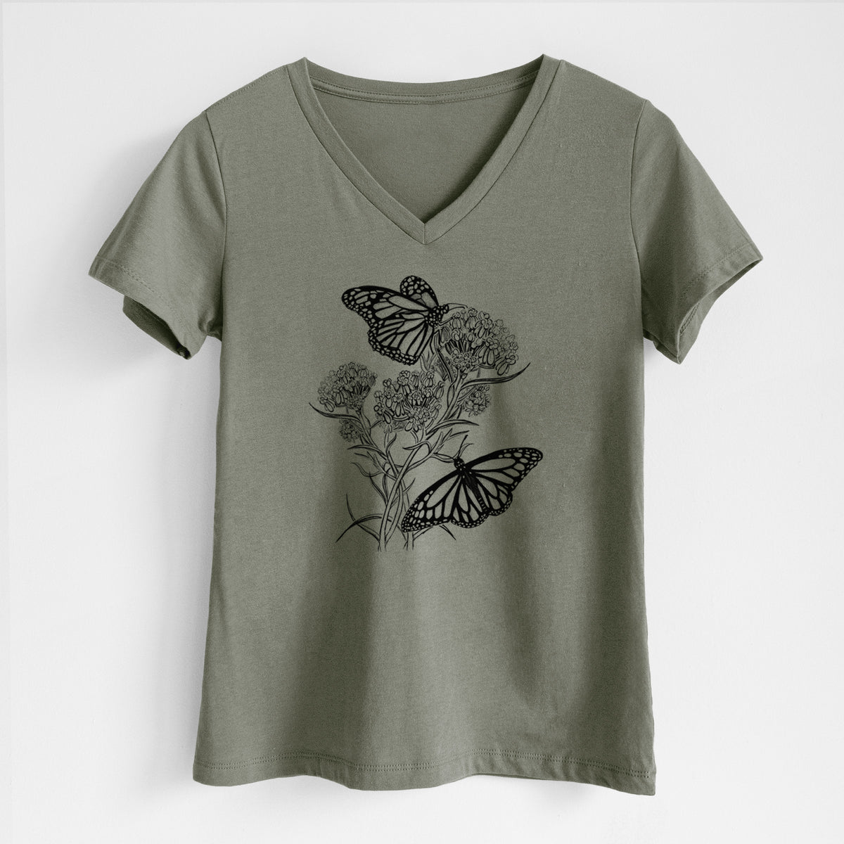 Military green women's relaxed fit cotton V-neck t-shirt laid flat, printed with a black ink illustration of two monarch butterflies on flowering milkweed.