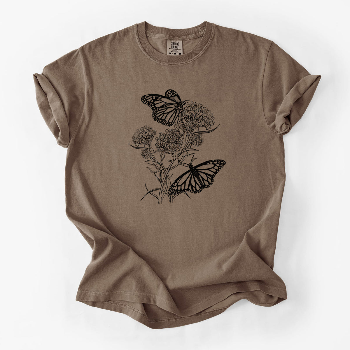 Espresso brown Comfort Colors t-shirt laid flat, printed with a black ink illustration of two monarch butterflies on flowering milkweed.