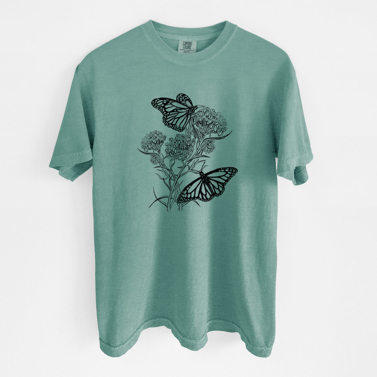 Reef green Comfort Colors t-shirt laid flat, printed with a black ink illustration of two monarch butterflies on flowering milkweed.