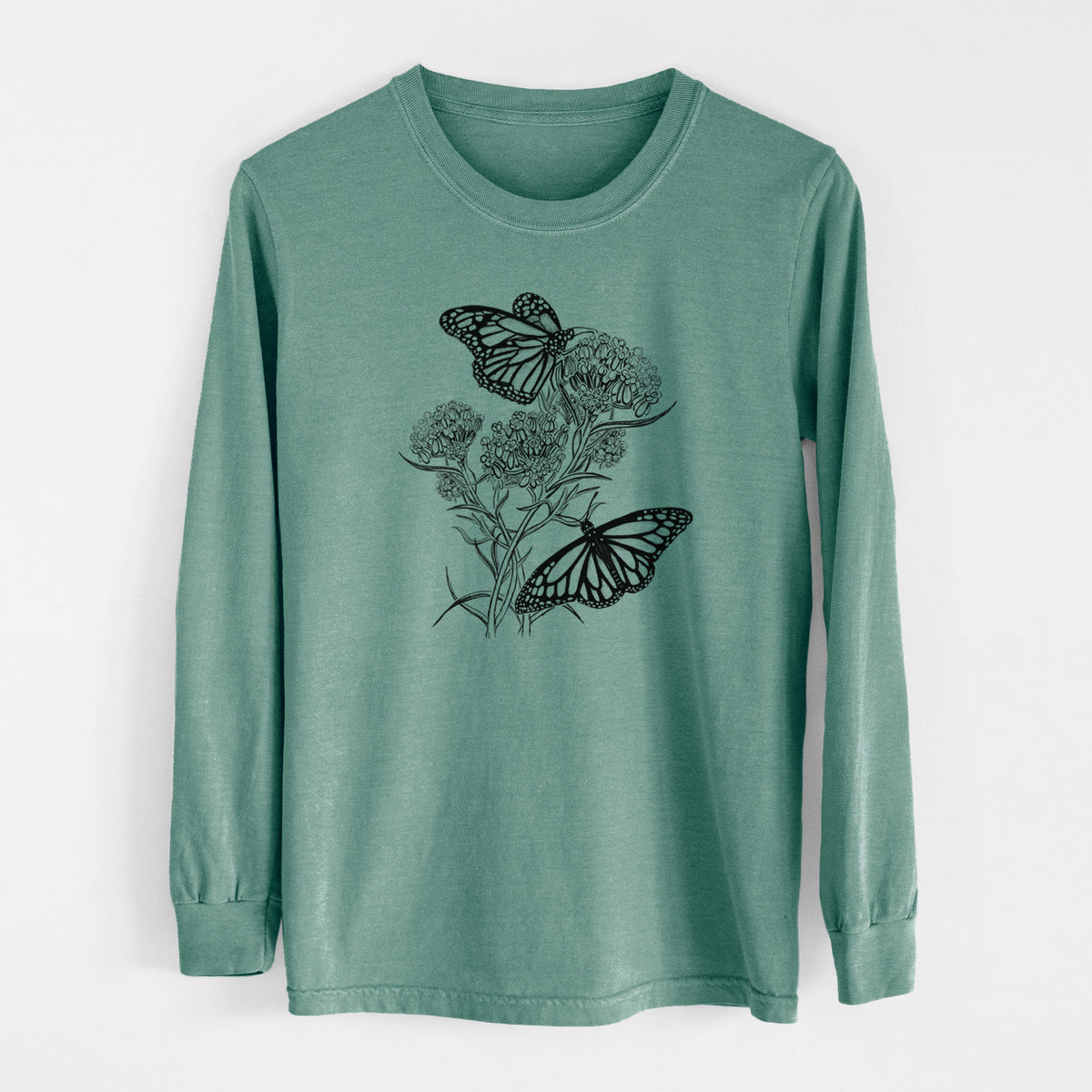 Pine green Comfort Colors long sleeve shirt laid flat, printed with a black ink illustration of two monarch butterflies on flowering milkweed.