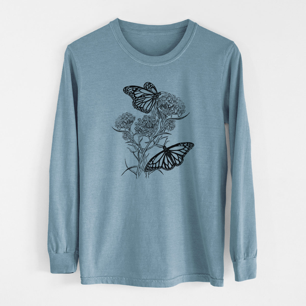 Steel blue Comfort Colors long sleeve shirt laid flat, printed with a black ink illustration of two monarch butterflies on flowering milkweed.