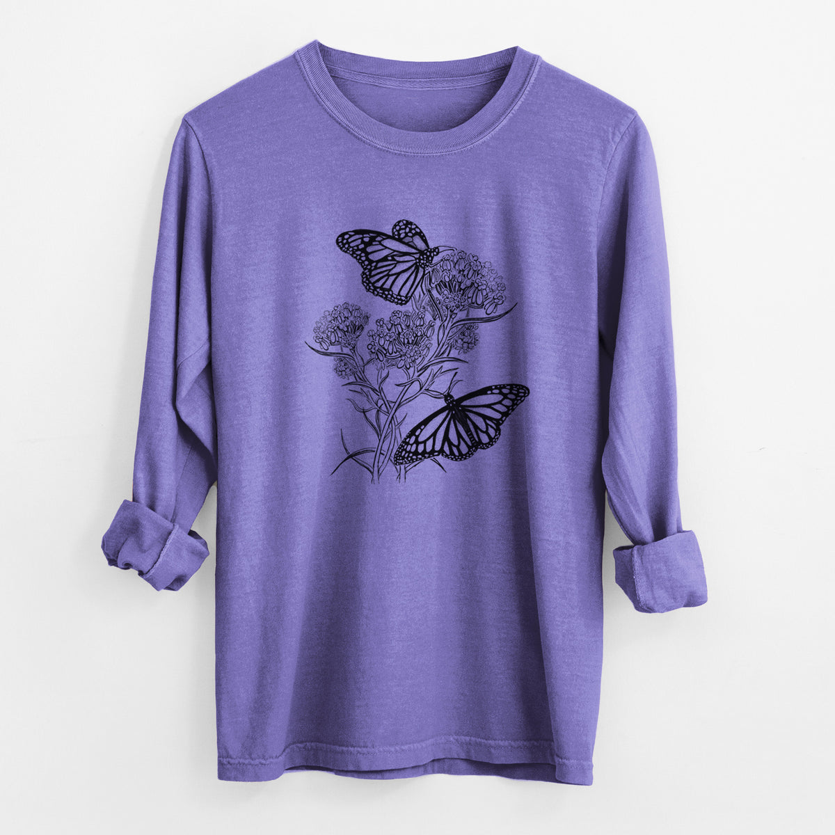 Violet purple Comfort Colors long sleeve shirt laid flat with the cuffs rolled, printed with a black ink illustration of two monarch butterflies on flowering milkweed.