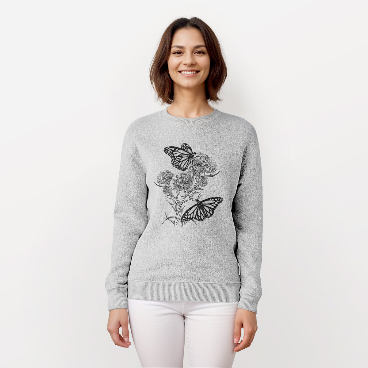 Woman wearing a knit sweatshirt printed with a black ink illustration of two monarch butterflies on flowering milkweed.