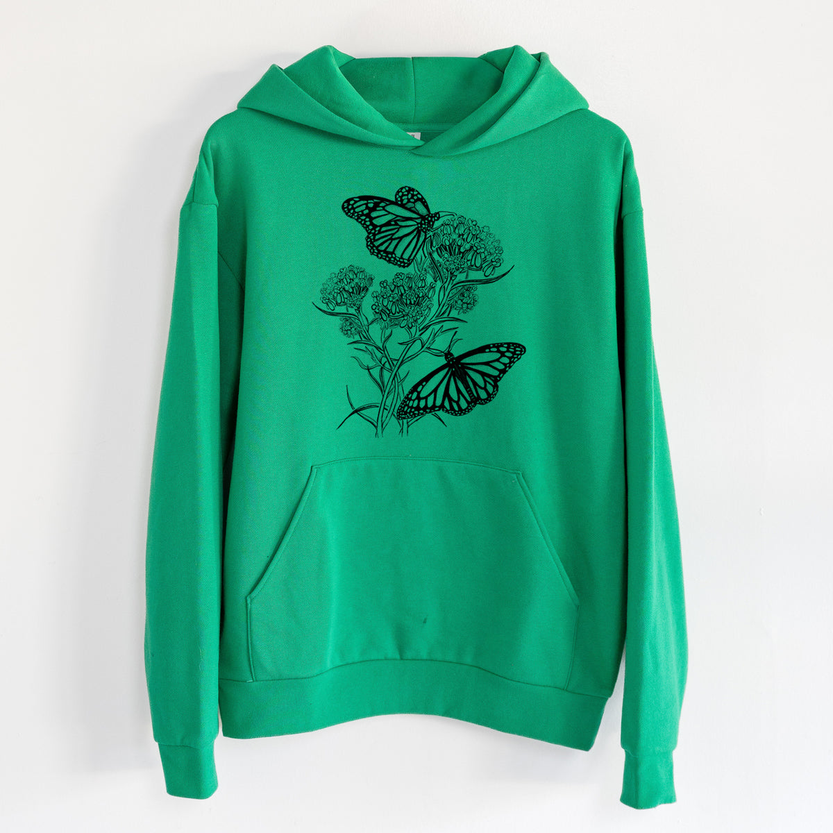 Narrowleaf Milkweed with Monarchs - Statement Midweight Hoodie in Kelly Green, hanging on a white wall, with a front kangaroo pocket and no drawcords.