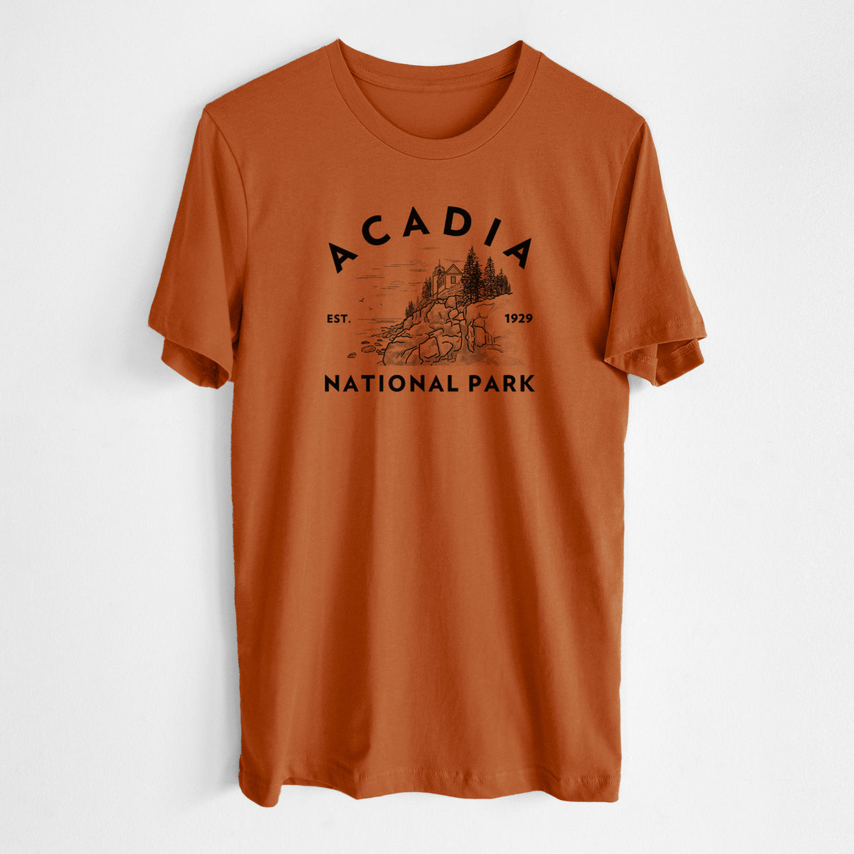 Autumn lightweight cotton t-shirt laid flat, printed with a round badge of a rocky coastline and pine trees, with the words Acadia National Park, Est. 1929.