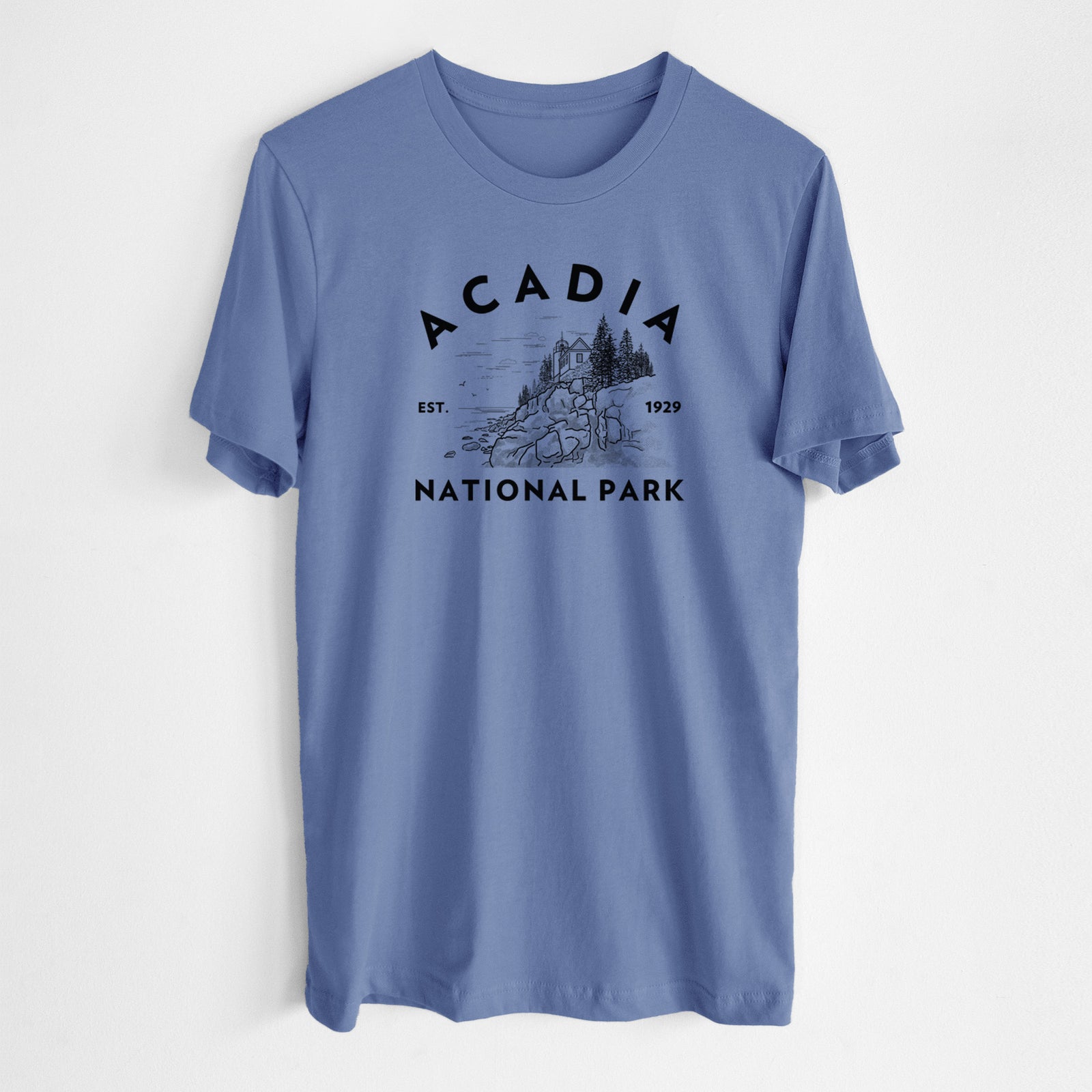 Blue bell lightweight cotton t-shirt laid flat, printed with a round badge of a rocky coastline and pine trees, with the words Acadia National Park, Est. 1929.