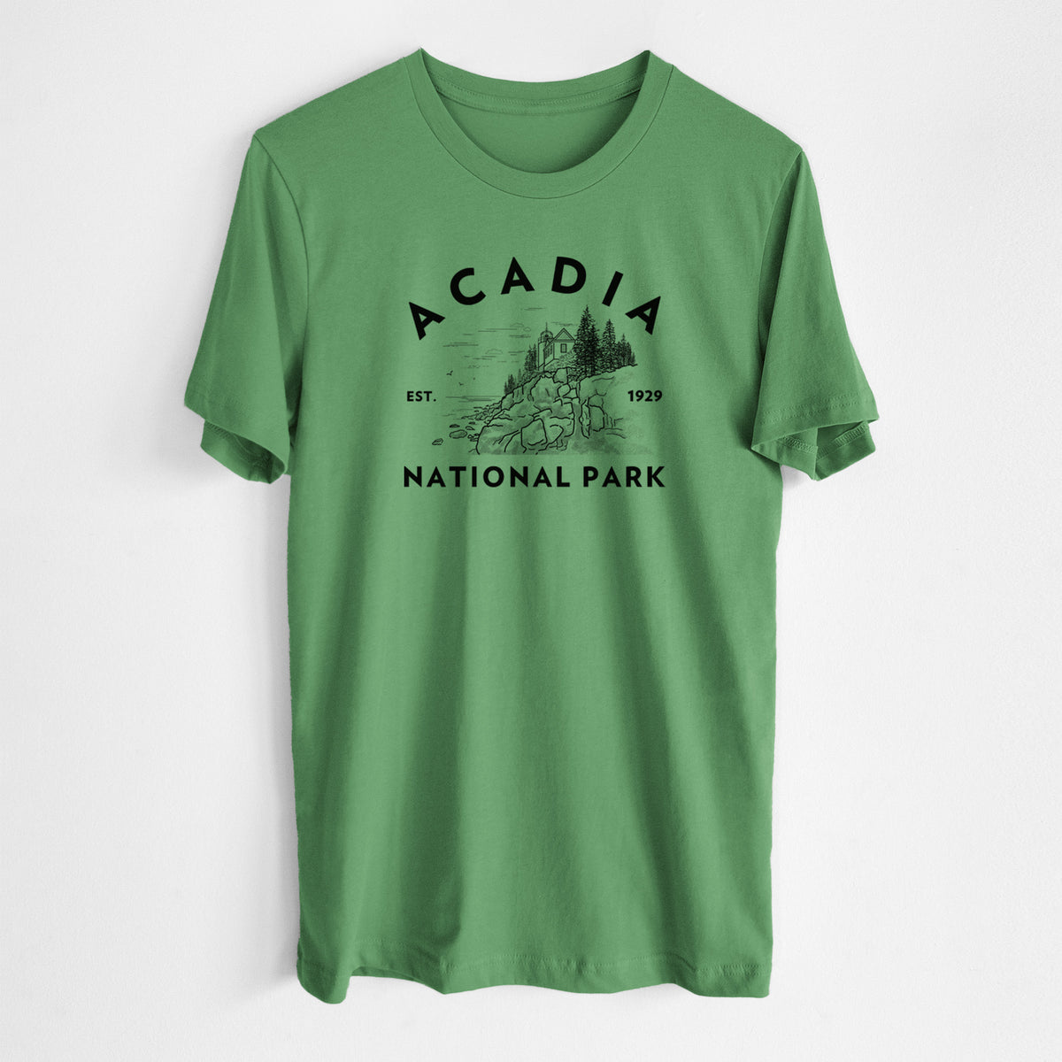 Leaf green lightweight cotton t-shirt laid flat, printed with a round badge of a rocky coastline and pine trees, with the words Acadia National Park, Est. 1929.