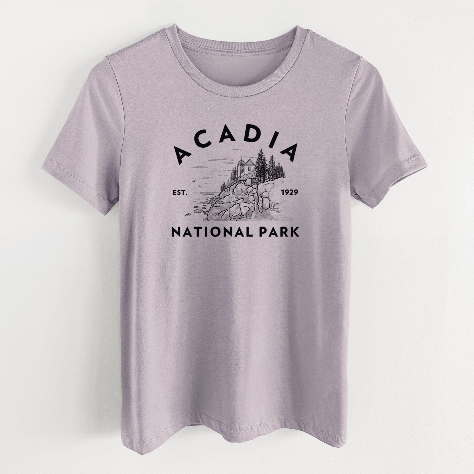 Light violet women's relaxed fit cotton t-shirt laid flat, printed with a round badge of a rocky coastline and pine trees, with the words Acadia National Park, Est. 1929.