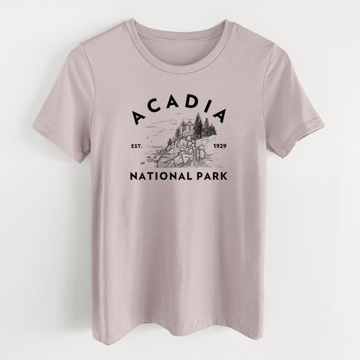Pink gravel women's relaxed fit cotton t-shirt laid flat, printed with a round badge of a rocky coastline and pine trees, with the words Acadia National Park, Est. 1929.