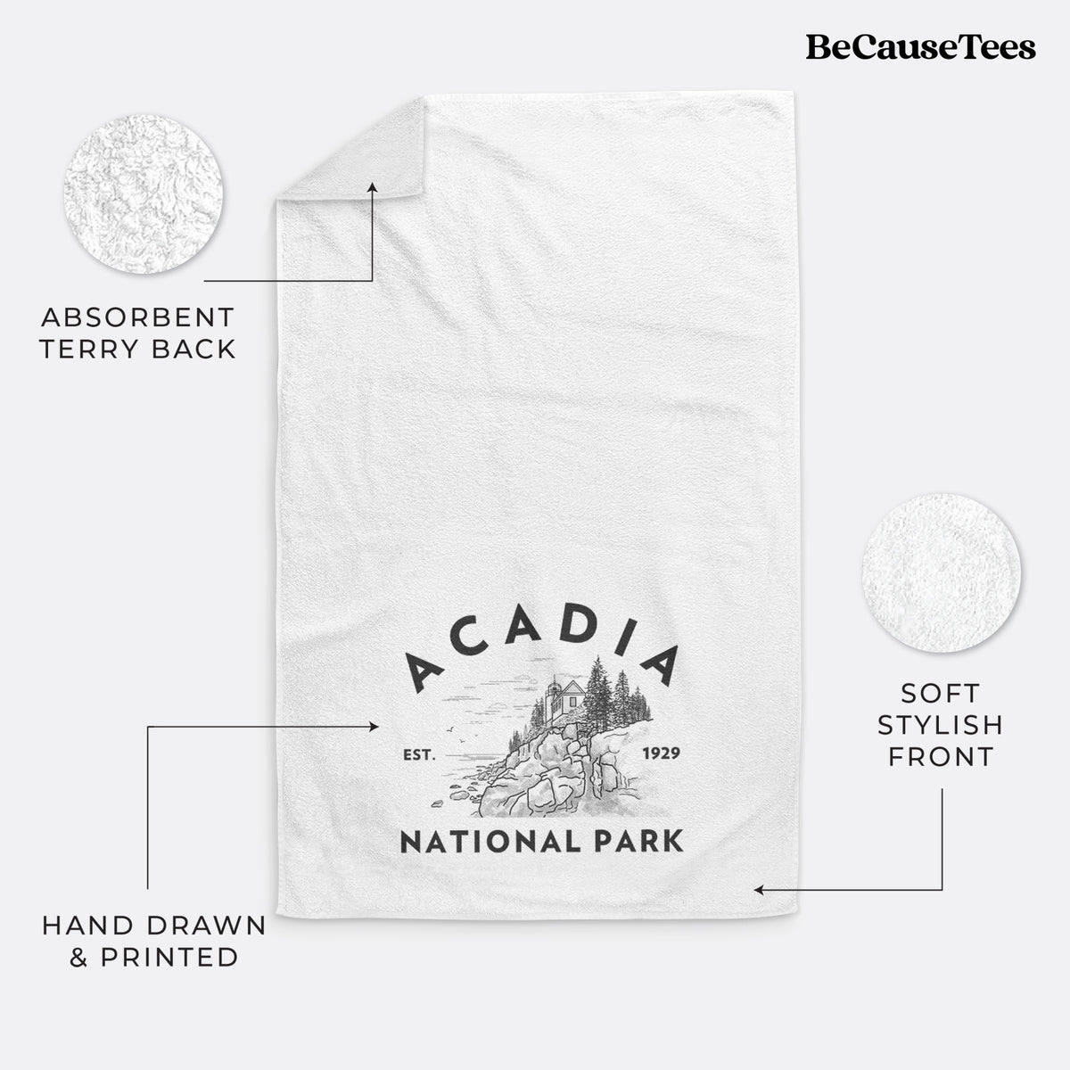 White hand towel printed with a round badge of a rocky coastline and pine trees, with the words Acadia National Park, Est. 1929.
