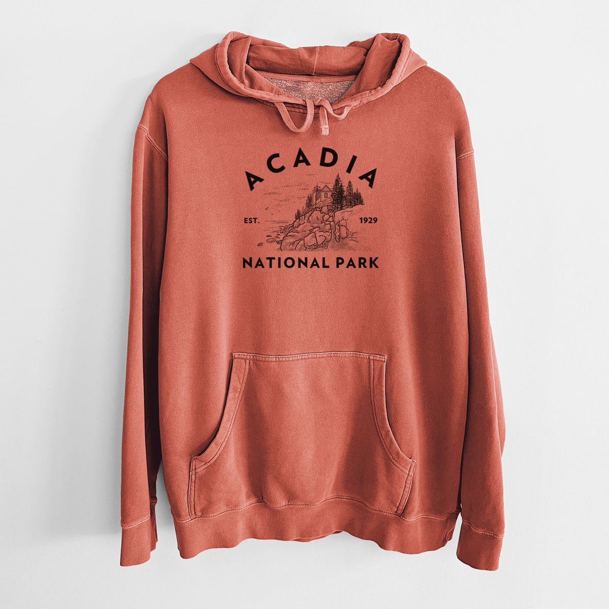 Amber orange pigment dyed hoodie laid flat, printed with a round badge of a rocky coastline and pine trees, with the words Acadia National Park, Est. 1929.